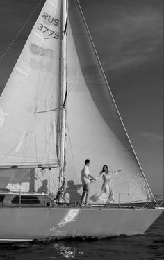 a man and woman on a sailboat in the ocean