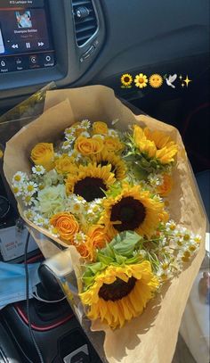 a bouquet of sunflowers is sitting on the dashboard of a car