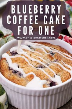 blueberry coffee cake in a white dish with icing drizzled on top