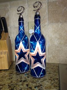 two blue glass bottles sitting on top of a counter