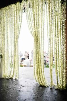 an open door with flowers on it and people in the background looking out at them