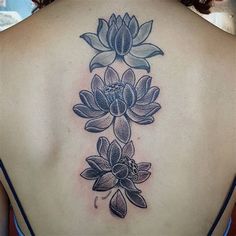 the back of a woman's upper body with flowers on her left shoulder and chest