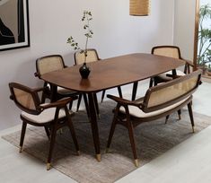 a dining room table with chairs and a vase on it