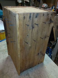 a wooden box sitting on top of a table next to a metal container with holes in it