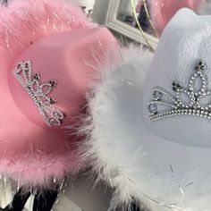 two hats with tiaras on them sitting next to each other