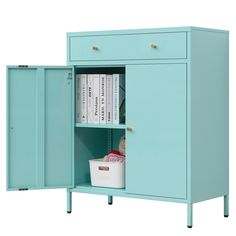 a blue cabinet with two doors open and some books on the shelf next to it