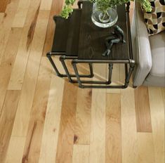 a living room with wood floors and furniture on it's side table, next to a couch