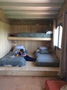 a person laying on the floor in a room with bunk beds