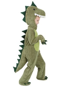 a little boy in a dinosaur costume is walking with his head turned to the side