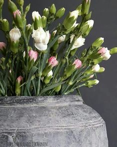 a vase filled with lots of white and pink flowers