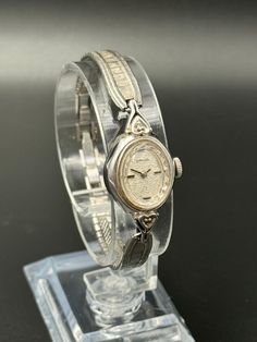 This exquisite vintage Baylor ladies watch showcases a timeless silver tone finish with a beautifully detailed textured bracelet and an elegant oval case. The intricate silver dial is adorned with delicate patterns, adding a touch of grace to this classic timepiece. Powered by a reliable mechanical movement, this watch runs and keeps time accurately. The case size is approximately 16.2mm, and it fits comfortably on a wrist size of up to 15.25cm. Please note the watch has minor cosmetic imperfections consistent with its age, which enhance its vintage character. --Please Read-- All sales are final except for damages in shipping or quality issues. Please feel free to ask questions before purchase. Offers are always welcomed, and we offer discounts for repeating customers. All international or Classic Silver Jewelry And Watches For Wedding, Vintage Silver Metal Jewelry And Watches, Vintage Silver Watches As Gifts, Vintage Silver Watches As A Gift, Silver Watch With Polished Finish For Wedding, Vintage Silver Jewelry And Watches For Gifts, Antique Silver Jewelry And Watches For Formal Occasions, Antique Silver Jewelry And Watches For Wedding, Vintage Silver Engraved Watch