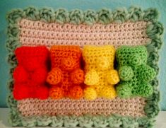 a crocheted frame with different colors of teddy bears on the front and sides