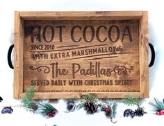 a wooden sign that reads hot cocoa with extra marshmallows and the pavillos served daily with christmas spirit