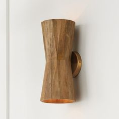 a wooden object mounted to the side of a white wall next to a light fixture