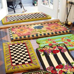 four rugs are lined up on the floor in front of an open door,