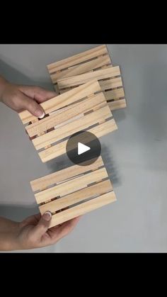 two hands holding pieces of wood that are stacked on top of each other, with the video below