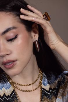 a woman is holding her hair up to her head with two rings on top of her head