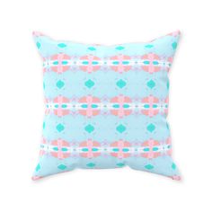 a blue and pink pillow with an abstract design on the front, sitting against a white background