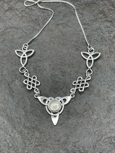 "I've fabricated a Celtic Irish inspired necklace with a center Celtic knot which features a center 8mm round cabochon, of your choosing in the drop down menu, with a total of three component pieces on either side. The sterling chain of 16 inches is soldered to each end making the approximate length of this piece just a bit over 18\" total. The chain will have a sturdy lobster claw. I've fabricated everything in sterling silver - it's a heirloom piece! This is a beautiful and feminine statement Teardrop Cabochon Necklace For Anniversary, Anniversary Cabochon Teardrop Necklace, Anniversary Teardrop Cabochon Necklace, Adjustable Cabochon Necklace As Gift, White Symbolic Necklace For Anniversary, Cabochon Round Pendant Jewelry For Weddings, Symbolic White Necklace For Anniversary, Adjustable Cabochon Round Pendant Necklace, Anniversary Pendant Necklaces With Cabochon