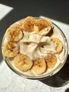 a dessert with bananas and cream in a glass bowl