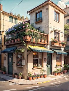 an old building with potted plants on the roof and balcony above it, in front of other buildings