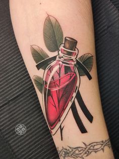 a tattoo with a red heart in a glass bottle on the arm and some black scissors