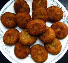 a white plate topped with fried food on top of a table