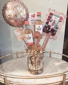 a table topped with a vase filled with liquor bottles and balloons next to a balloon