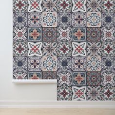 a wall with an artistic tile design in blue, red and white colors on it