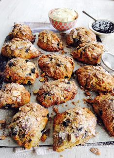 a table topped with muffins covered in powdered sugar next to a bowl of dip