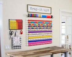 a table with some scissors on it in front of a wall mounted crafting kit