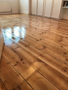 an empty room with hard wood floors and white walls