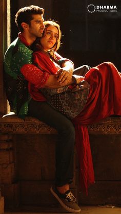 a man and woman sitting next to each other on a ledge in front of a window