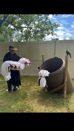 two people in costumes are holding bags with blood on them and one person is standing next to a trash can