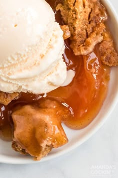 a white plate topped with apple pie and ice cream covered in caramel glaze