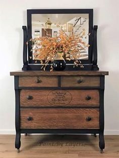 an old dresser with a mirror on top and flowers in the bottom drawer is shown