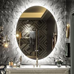 a bathroom with a round mirror above the sink and gold accents on the wall behind it