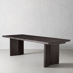 a long wooden table sitting on top of a white floor next to a gray wall