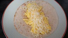 a tortilla topped with cheese and other toppings on a blue and white plate