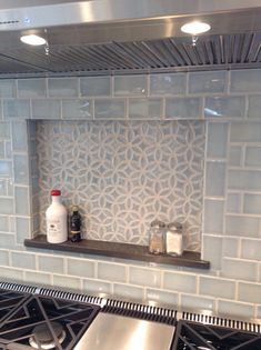 a stove top oven sitting inside of a kitchen next to a counter with a bottle on it