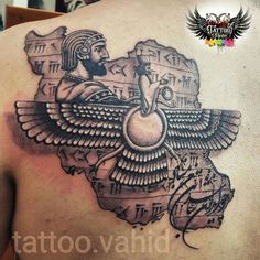 the back of a man's shoulder with an egyptian tattoo design on his chest