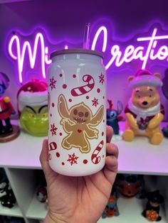 a person holding up a cup in front of a shelf with teddy bears and other toys