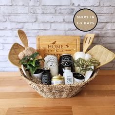 a basket filled with kitchen utensils on top of a wooden table next to a brick wall