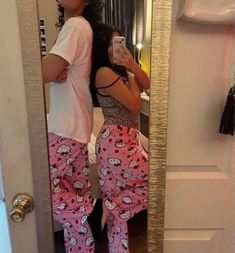 a woman taking a selfie in front of a mirror wearing hello kitty pajama pants