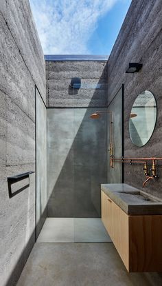 a modern bathroom with concrete walls and floor, along with a walk in shower area