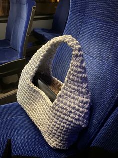 a crocheted purse sitting on top of a blue seat