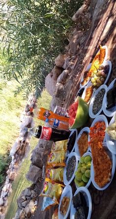 several bowls filled with different types of food sitting on the side of a stone wall