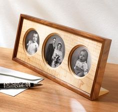 a wooden frame with three pictures and a pen