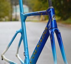 a blue bicycle parked on the side of a road