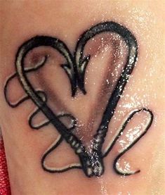 a heart tattoo on the side of a woman's stomach, with black ink